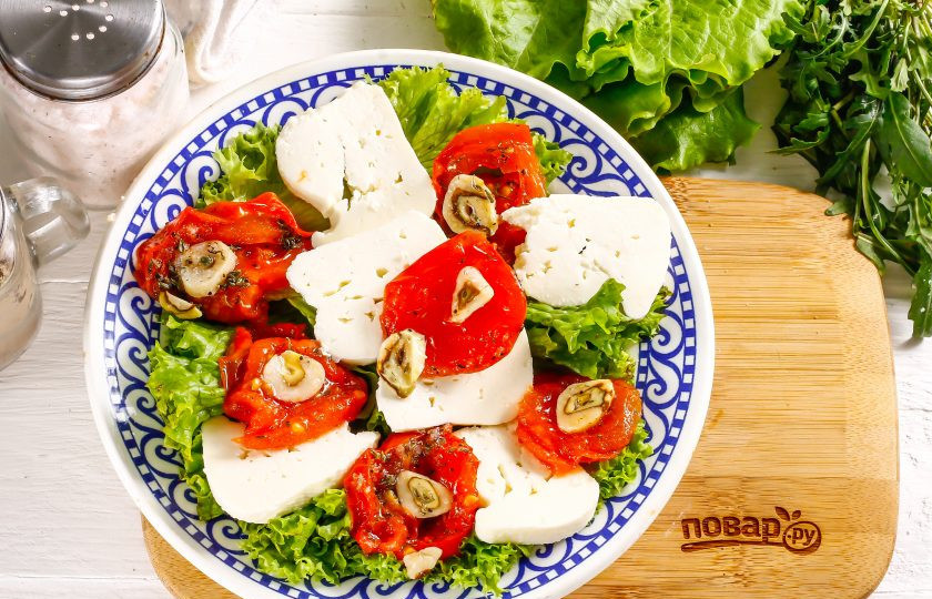 1. Этап. Салат с вялеными помидорами и рукколой: Нарежьте мягкий сыр: брынзу (фету), сулугуни, моцареллу небольшими кусочками или кружочками, выложите на тарелку между помидоров.