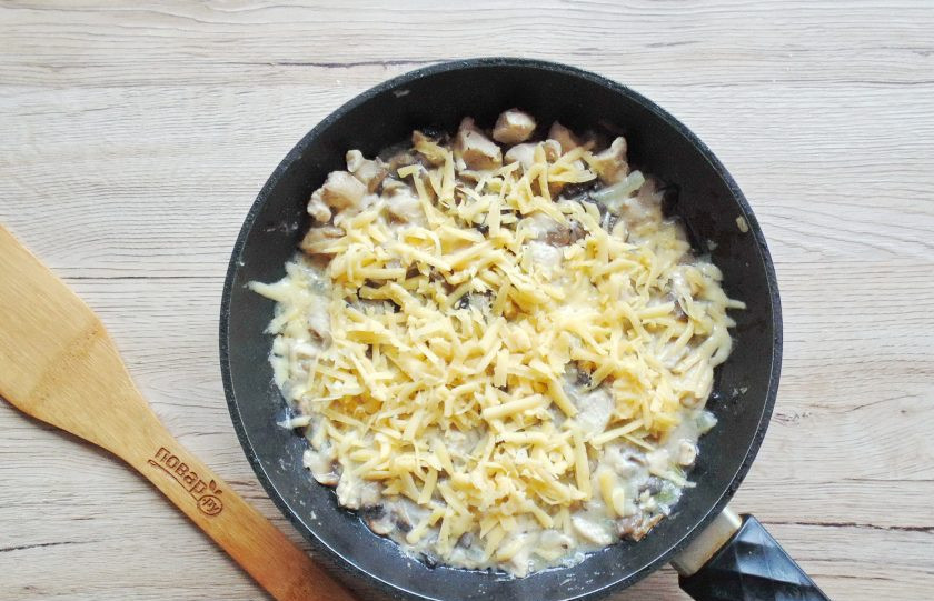 1. Этап. Жульен с курицей и грибами на сковороде: Готовый жульен посыпьте тёртым сыром и накройте сковороду крышкой.