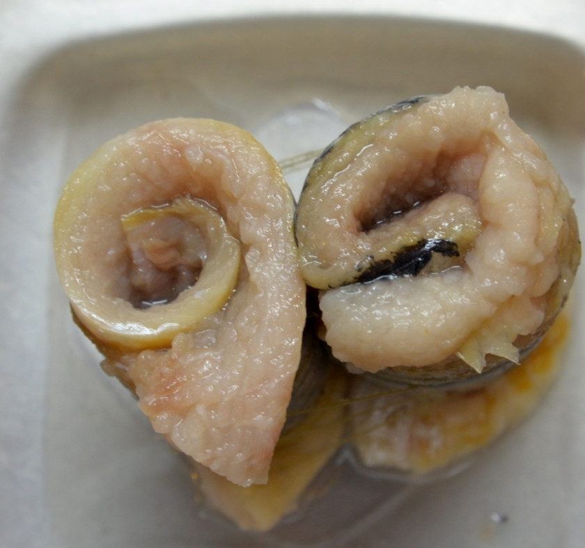 1. Этап. Рулетики из сельди в маринаде: Сверните его в рулеты, затем (плотно друг к другу) выложите в глубокую посуду.