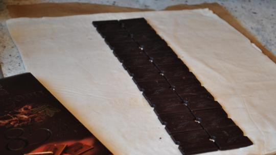 1. Этап. Косичка с шоколадом из слоеного теста: Выкладываем посередине раскатанного листа теста плитку шоколада.