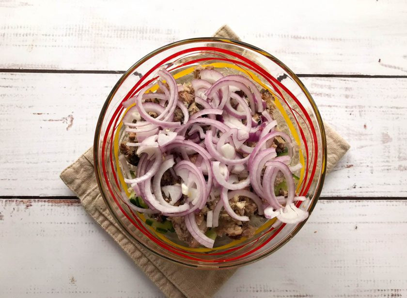 1. Этап. Салат с красной фасолью и рыбой: Лук очистите от шелухи, нарежьте полукольцами и добавьте к остальным ингредиентам.