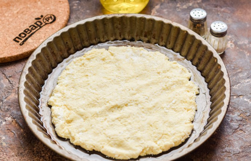 1. Этап. ПП пицца на творожном тесте: Форму для духовки смажьте маслом, выложите тесто, разравнивая его пальцами.