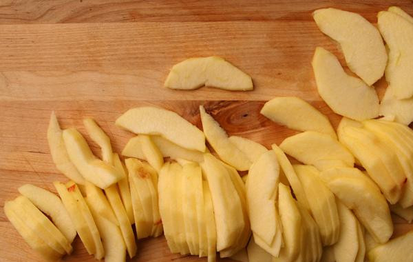 1. Этап. Эльзасский яблочный пирог: 2. Разрезать половинки яблок толстыми ломтиками (около 6-10 мм толщиной). У вас получится около 12 кусочков от каждого яблока. Выложить ломтики яблок друг на друга, чтобы они перекрывали друг друга. Ничего страшного, если ломтики яблок выходят за края корочки. В миске или мерной чашке миксером взбить жирные сливки, сахар, яйцо, яичный желток и ванильный экстракт. Вылить полученную смесь поверх яблок. Это будет заварной крем.