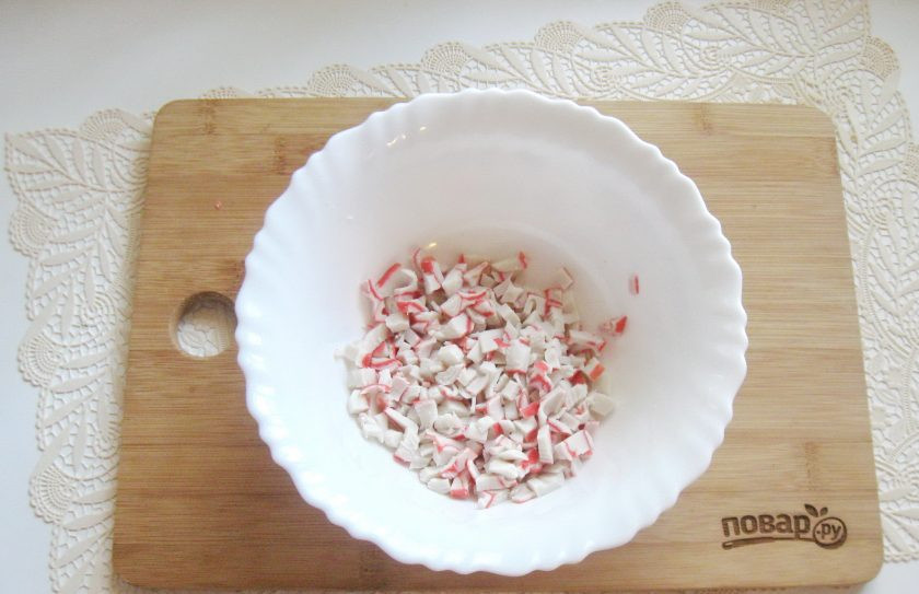 1. Этап. Салат Балтийский: Крабовые палочки или крабовое мясо мелко нарежьте и выложите в салатник.