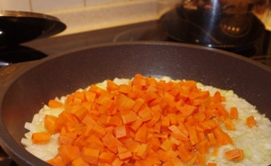 1. Этап. Картошка, тушенная с мясом и грибами: Чистим лук и морковь. Нарезаем и то, и другое небольшими кубиками. Обжариваем на сковороде с ложкой растительного масла.