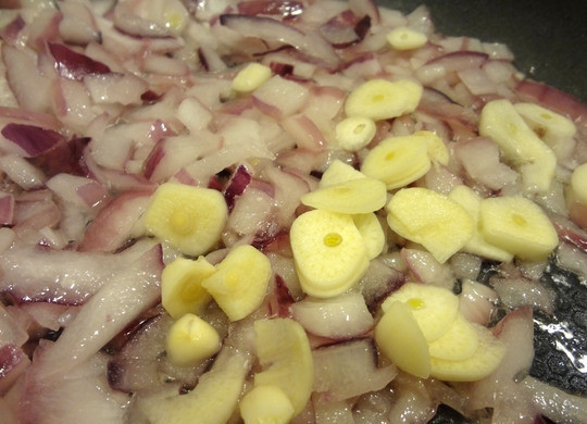 1. Этап. Фасоль с шампиньонами: 2. Чеснок чищу и нарезаю его тонкими пластинами, отправляю в сковороду к луку.