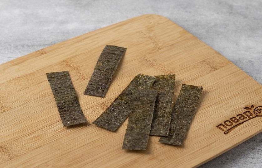 1. Этап. Картофельные лепешки Имомоти: Нарежьте лист нори на полосы шириной 2-3 см. Оберните в них картофельные лепешки.