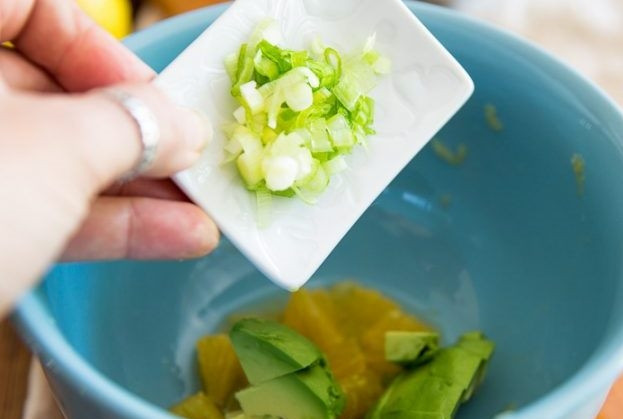 1. Этап. Салат с сёмгой: Положите мякоть апельсина и авокадо в миску. Очистите лук, нарубите его как можно мельче. Отправьте лук в пиалку к остальным ингредиентам.