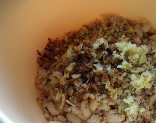 1. Этап. Салат к борщу: Когда фасоль сварится, слить с нее воду. Фасоль охладить и выложить в салатник. Добавить к ней обжаренный лук, орехи и чеснок. Посолить и поперчить.