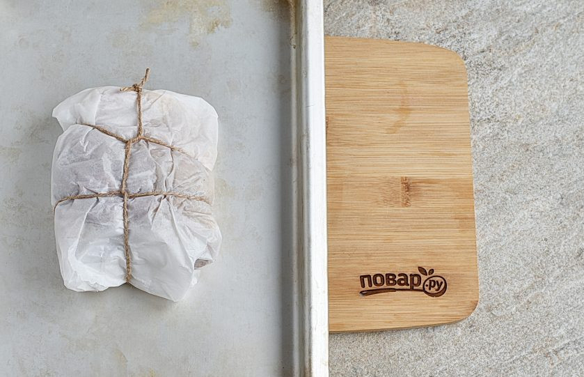 1. Этап. Маринад для буженины: Заверните мясо в пергамент для выпечки хорошего качества, перевяжите шпагатом. Выложите на лист. Запекайте в духовке при 200 градусах 20 минут. Затем убавьте нагрев до 120 градусов и запекайте до готовности. Время зависит от веса куска. На килограмм мяса нужен один час. Проверьте готовность мяса проколом через пергамент и слегка придавите мясо – сок должен быть прозрачным.