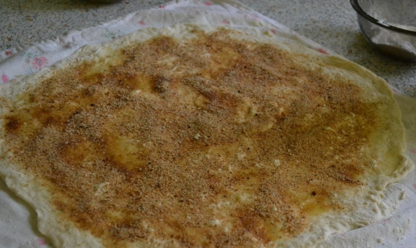 1. Этап. Яблочный штрудель из бездрожжевого теста: 7. Посыпаю тесто сахарной пудрой, смазываю его подтаявшим сливочным маслом, а затем посыпаю панировочными сухарями.