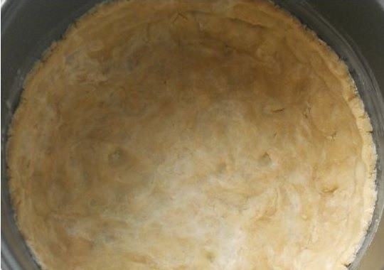 1. Этап. Цветаевский яблочный пирог в мультиварке: 3. Чашу мультиварки смажьте сливочным маслом. Выньте тесто из холодильника и распределите равномерным слоем по дну чаши, делая бортики высотой около 5 – 7 см.