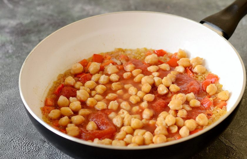 1. Этап. Пилав из булгура с нутом: Влейте бульон, добавьте нут и рубленые томаты. Доведите до кипения. Накройте крышкой, и варите на медленном огне 15 минут. Жидкость должна полностью впитаться.