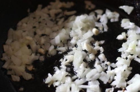 1. Этап. Плов из красного риса: Первым делом мы наливаем в глубокую сковороду (с толстыми стенками) растительное масло и нагреваем его. В масло выкладываем нарезанный мелко репчатый лук и чеснок, обжариваем овощи до золотистого цвета.