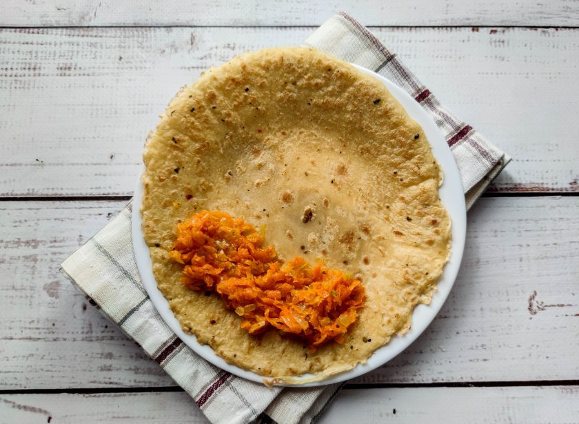 1. Этап. Блинчики с морковной начинкой: Выложите один блинчик на тарелку, а сверху выложите начинку из жареной моркови с луком.