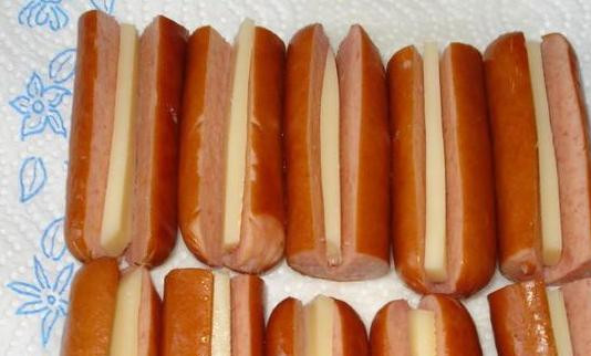 1. Этап. Сосиски в капустных листьях: Сосиски очищаем от кожуры, надрезаем и внутрь вставляем полосочки сыра. Можно обойтись и без него, с сыром интереснее.