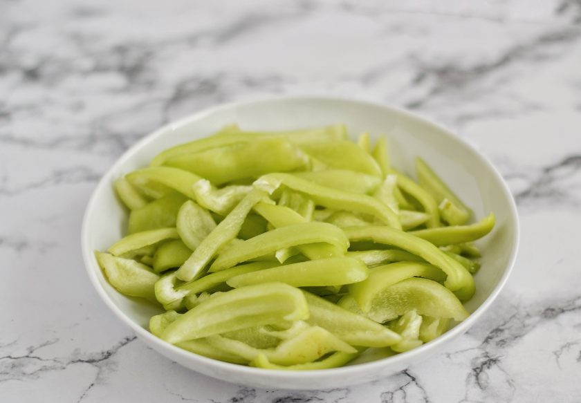 1. Этап. Зеленый болгарский перец на зиму: У перцев отрежьте хвостики и удалите сердцевину. Нарежьте перцы вдоль соломкой.