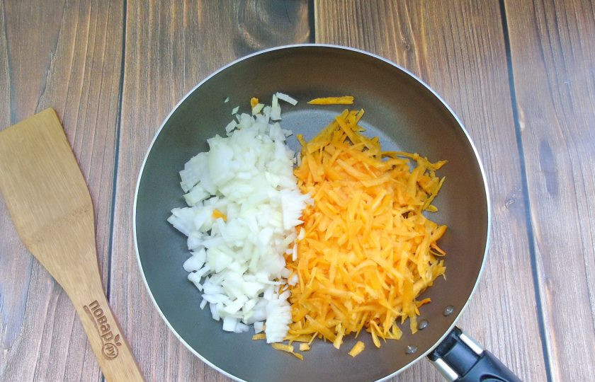 1. Этап. Рубленые котлеты из индейки и тыквы в духовке: Репчатый лук и тыкву очистите, помойте. Лук мелко нарежьте, а тыкву натрите на терке. Выложите в сковороду с подсолнечным маслом.