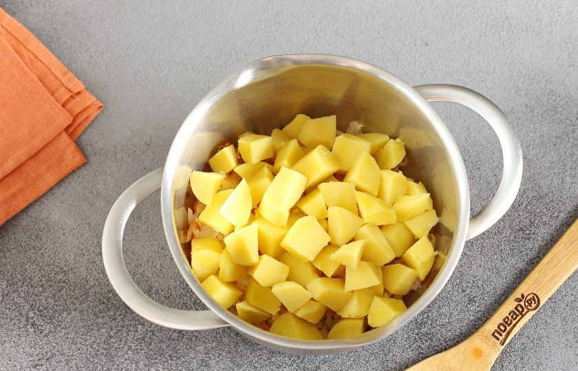 1. Этап. Салат Погребок: Картофель очистите, нарежьте небольшими кубиками и добавьте к капусте.