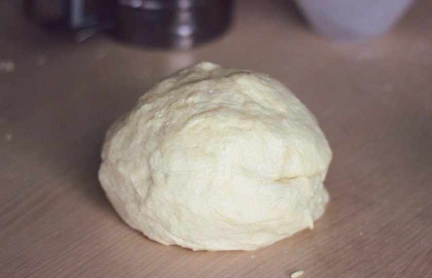 1. Этап. Творожное печенье к чаю: Теперь добавляем муку, просеянную с разрыхлителем. Просеиваем 1 стакан муки, тщательно перемешиваем ложкой. Затем просеиваем второй стакан — и выкладываем тесто на рабочую поверхность, присыпанную мукой. Замешиваем тесто. При необходимости добавляем оставшиеся полстакана муки. Все зависит от выбранного вами творога, но я не рекомендую брать мягкий. Тщательно замешиваем тесто, оно станет очень мягким и податливым. Скатываем из него шар, накрываем на 30 минут полотенцем.