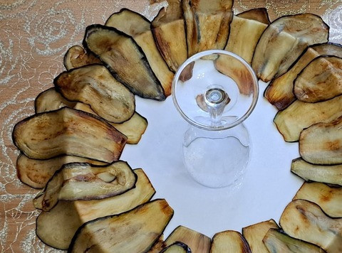 1. Этап. Салат с баклажанами и индейкой: На крушлой тарелке, разложить баклажаны внахлест друг друга, чтобы концы свисали с краёв. А в центр тарелки поставить, стакан, кружку или бокал.