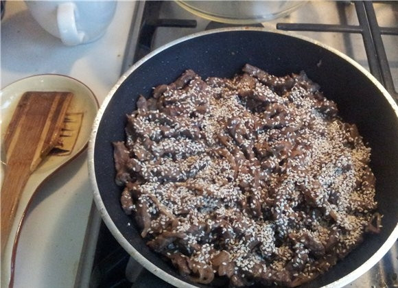 1. Этап. Говядина по-японски: Обжариваем мясо с луком на довольно сильном огне, пока цвет лука не станет золотистым, всыпаем кунжут.