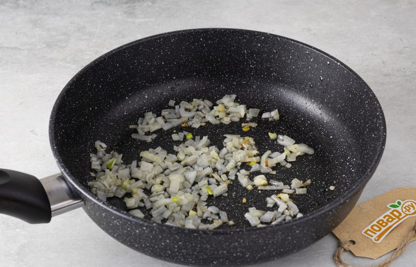 1. Этап. Икра из цукини: Нарежьте репчатый лук на мелкие кубики, затем обжарьте пару минут в сковороде с маслом до прозрачности.