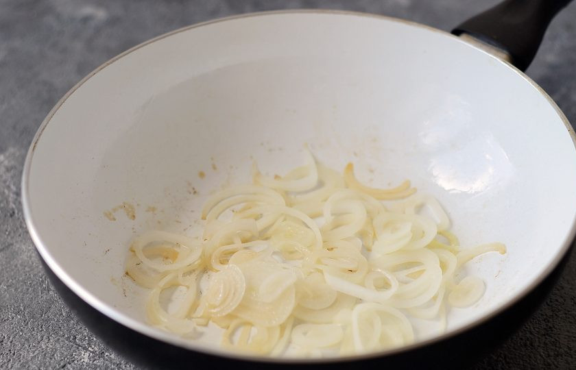 1. Этап. Салат с баклажанами по-армянски: Добавьте в сковороду еще масла и слегка припустите лук до мягкости.