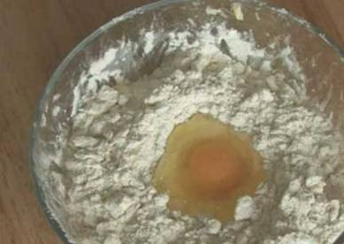 1. Этап. Наполеон со сгущенкой: Теперь сделаем в муке углубление, туда вбиваем яйцо и добавляем щепотку соли.