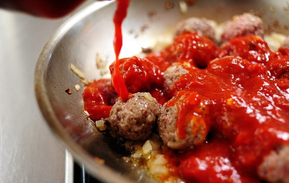 1. Этап. Мини-бургеры с фрикадельками: 4. Полейте фрикаделки томатной пастой. Обжаривайте их до готовности.