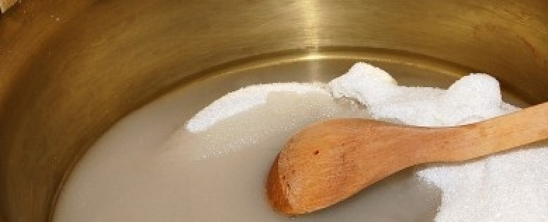 1. Этап. Варенье из брусники с грушами: 3. Высыпьте сахар в кастрюлю и добавьте к нему воды, чтобы он быстрее растворился. Постоянно помешивайте деревянной ложкой, чтобы сахар не пригорел.