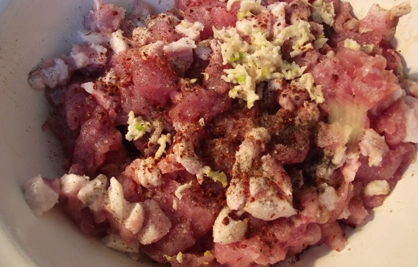 1. Этап. Домашняя колбаса из индейки в кишке: Индейку порубите мелко, через мясорубку пропускать не нужно. Добавьте мелко порезанное кубиками сало, специи, кориандр, мускатный орех, коньяк, а также чеснок. Все хорошенько перемешайте и оставьте мариноваться на часа 3.