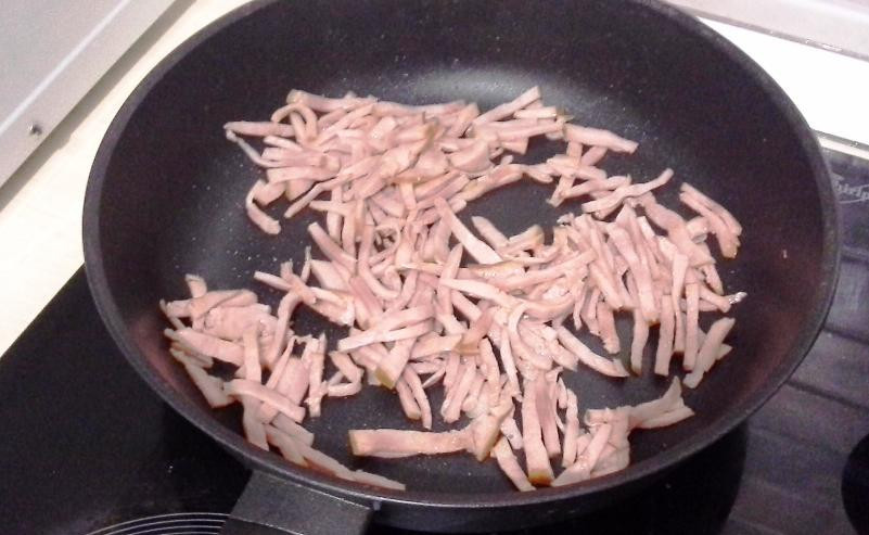 1. Этап. Паста с ветчиной и грибами в сливочном соусе: Отдельно обжарьте порезанную соломкой ветчину. Её жарьте 2-3 минуты на среднем огне с ложкой оливкового масла.