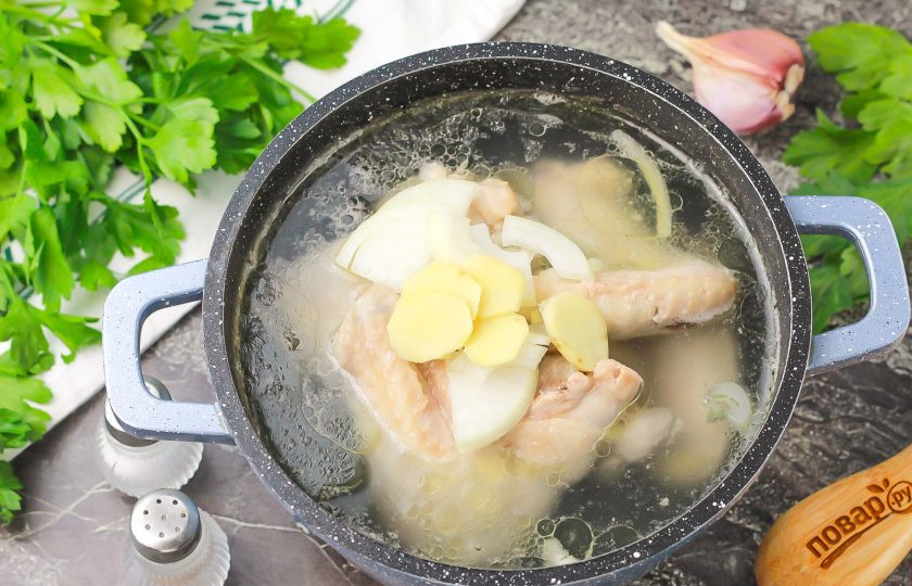 1. Этап. Китайский куриный бульон: Спустя указанное время очистите корень имбиря, лук и зубчики чеснока. Промойте в воде и нарежьте слайсами, а лук — полукольцами. Добавьте в бульон.