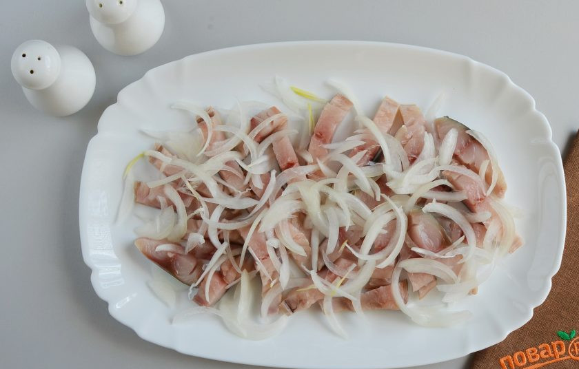 1. Этап. Салат со скумбрией: Порежьте лук тонкими полукольцами, выложите поверх рыбы.