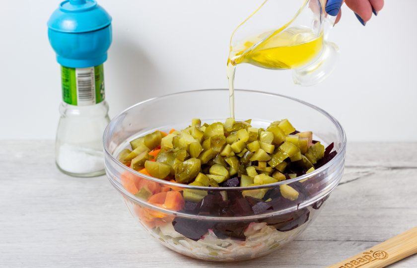 1. Этап. Винегрет без картошки: Добавьте в салат ароматное подсолнечное масло, перемешайте. При необходимости посолите по вкусу, но как правило соли достаточно от огурцов и капусты.