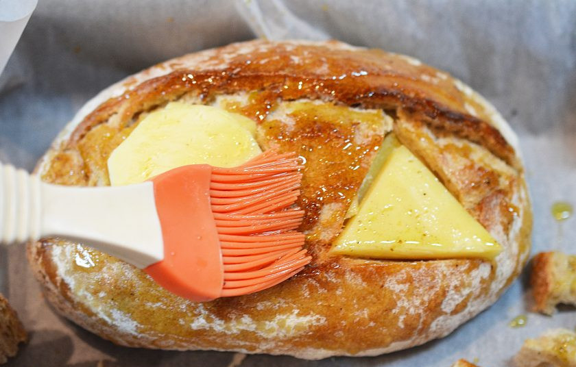 1. Этап. Сырный дип в батоне: Смешайте масло с приправами и смажьте хлеб, сыр и полоски хлеба.