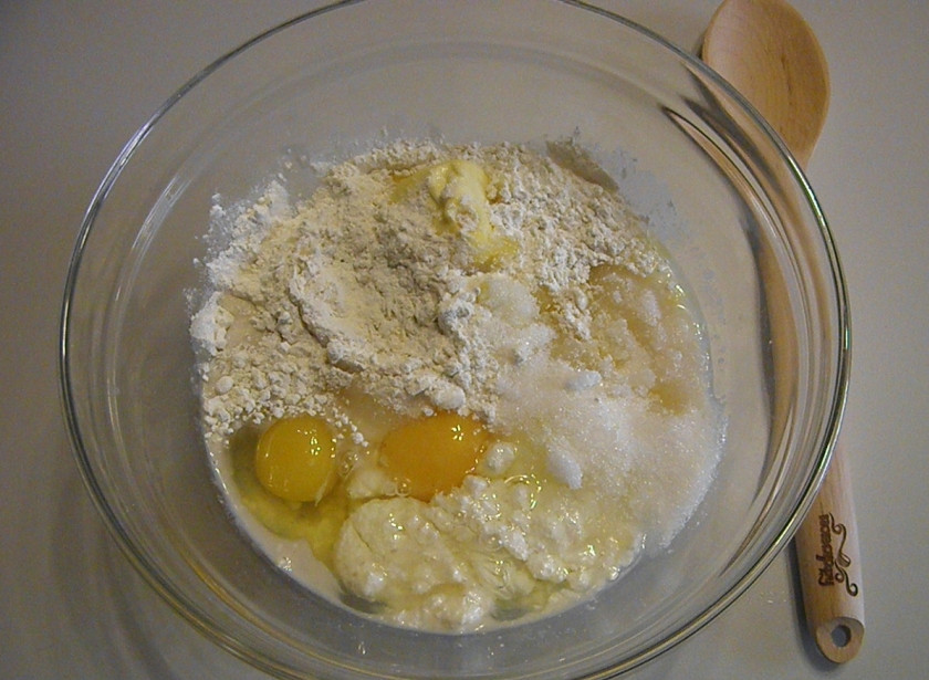 1. Этап. Творожные булочки в сметанной заливке: Чтобы приготовить тесто творожное, нужно растворить дрожжи свежие в теплом молоке со щепоткой соли. Потом добавьте сахар, яйца (один желток я оставила для смазывания булочек), мягкое сливочное масло, протертый через сито творог, ванилин или ванильный сахар и стакан муки. Тщательно перемешайте жидкое тесто.