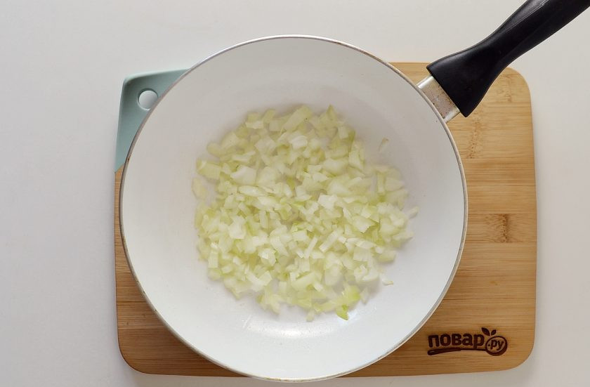 1. Этап. Овощной суп без мяса с капустой: Параллельно нарежьте лук кубиками, обжарьте на сковороде с маслом до мягкости.