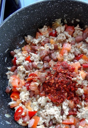 1. Этап. Шаурма-бурито из индейки на гриле: Добавить в сковороду паприку и томат. Перемешать. Посолить и поперчить по вкусу. Готовить на медленном огне буквально минуту.