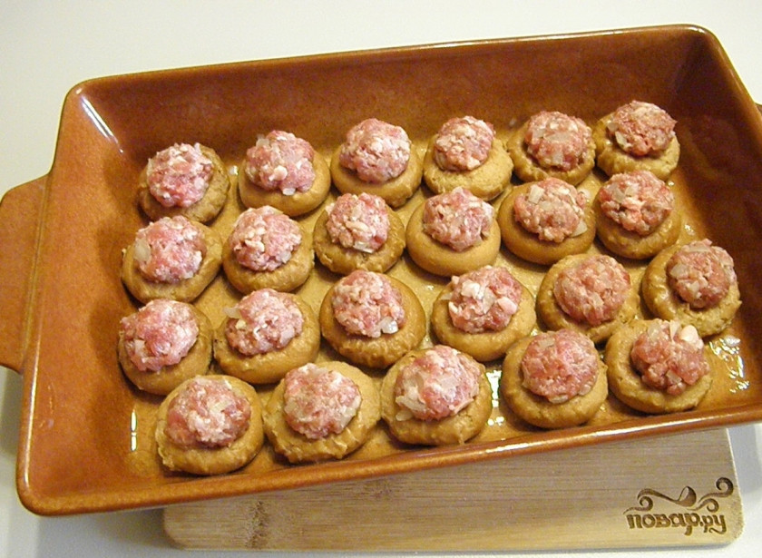 1. Этап. Бублики с фаршем в духовке: Заполните каждый бублик шариком фарша. Фарш нужно немного вдавливать внутрь. Отправьте фаршированные бублики на 15 минут в горячую духовку (температура выпекания — 180 градусов).