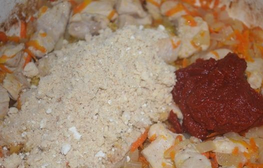 1. Этап. Гуляш из куриного филе: Высыпаем муку к куриному филе с овощами, добавляем томатную пасту.