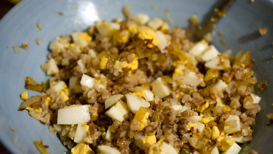 1. Этап. Рыба начиненная кашей: 3. Очистите, измельчите луковицу, отправьте её на сковороду с растопленным сливочным маслом. Обжарьте до золотистого цвета. Затем переложите туда гречку (а именно она используется в этом рецепте приготовления рыбы, начиненной кашей) и нарезанные кубиками яйца. Все как следует перемешайте, при желании добавьте специи.