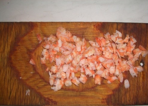 1. Этап. Салат с креветками и кальмаром: Креветки кидаем в кипящую подсоленную воду и варим минуты 3. Затем остужаем их, чистим и мелко нарезаем. Часть оставляем целыми для украшения салата.