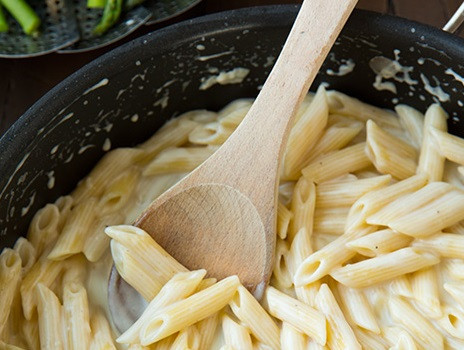 1. Этап. Пенне с курицей и спаржей: 1. Смешайте в мисочке специи - базилик, орегано, тимьян, соль и перец. Куриную грудку нарежьте кубиками. Посыпьте курицу специями. Обжарьте на растительном масле на средне-высоком огне до золотистого цвета, минут 10-12, затем выложите в тарелку. Пенне отварите согласно инструкции, слейте, сохранив полстакана воды, в которой паста варилась. В большой сковороде на среднем огне растопите сливочное масло. Добавьте муку, постоянно помешивая, жарьте минуту. Затем добавьте пропущенный через пресс чеснок. Через полминуты введите, помешивая, молоко и сливки. Доведите до кипения, затем огонь понизьте до средне-медленного. Введите сыр, перемешайте до однородной консистенции и добавьте пенне.