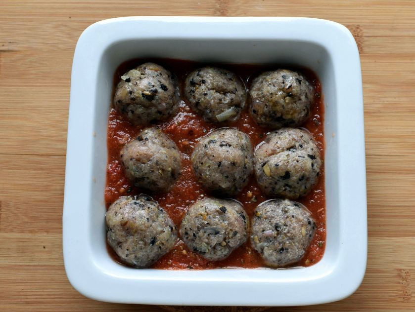 1. Этап. Тефтели индюшиные с грибами: Налейте на дно формы немного соуса и выложите тефтельки.