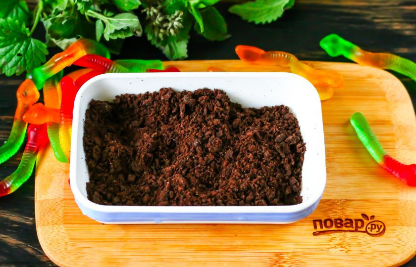 1. Этап. Десерт с червями и Орео на Хэллоуин: Отделите половинки печенья друг от друга, соскоблите крем. Половинки печенья искрошите в пиалу или креманку – получится сладкая темная земля.