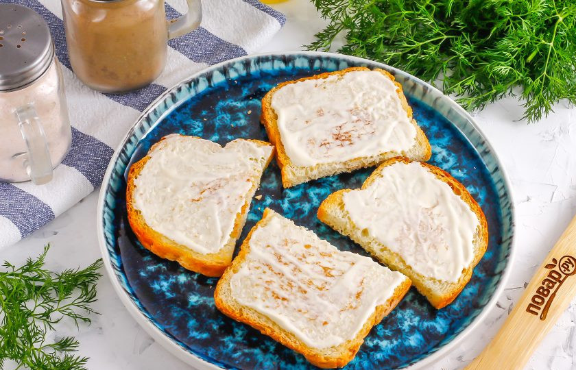 1. Этап. Брускетты с печенью трески: Смажьте каждый ломтик хлеба майонезом любой жирности, можно использовать постный майонез или чесночный.