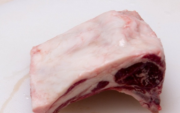 1. Этап. Баранина со сливами: Для начала обрезаем с бараньей корейки лишний жир и промываем мясо под проточной водой. Вытираем его насухо и посыпаем солью и молотым перцем.