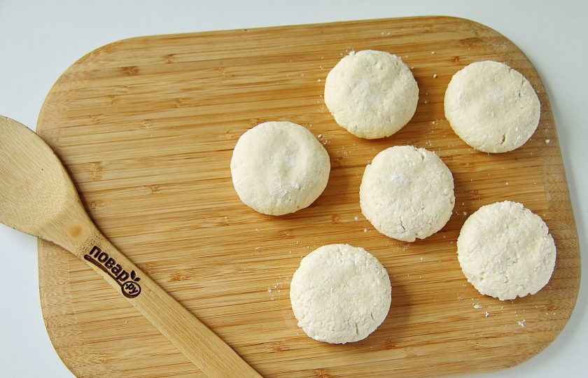 1. Этап. Сырники с кокосовой стружкой: Сформируйте пухлые сырники и хорошо обваляйте их в муке.